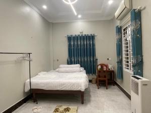 um pequeno quarto com uma cama e uma cadeira em Bun Homestay em Battambang