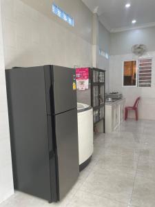 uma cozinha com um frigorífico preto num quarto em Bun Homestay em Battambang