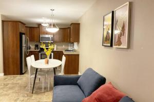 a living room and kitchen with a table and a couch at NairaVilla: upscale accommodation for groups in Regina