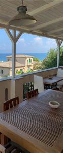 un tavolo di legno su un balcone con vista sull'oceano di B&B Villa Delle Rondini a Vibo Valentia Marina