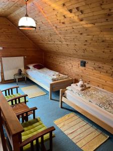 Zimmer mit 2 Betten und Stühlen in einer Hütte in der Unterkunft Apartments Jelka in Kranjska Gora