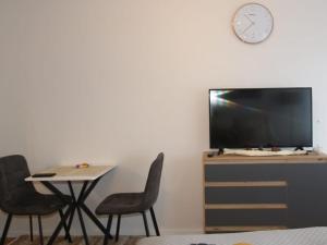 a living room with a table and a tv and chairs at Ferienwohnung in Freilassing