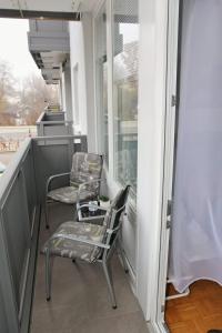 2 sillas sentadas en un balcón junto a una ventana en Ferienwohnung, en Freilassing