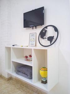 a white shelf with a tv on a wall at Steve's House in Puerto Iguazú