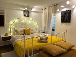 a bedroom with a bed with a yellow bedspread at HealthyStudio512 Apartments in Kotor
