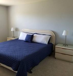 1 dormitorio con 1 cama azul y 2 mesitas de noche en Entire 2 level townhouse in Old Town Scottsdale!, en Scottsdale