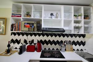 a kitchen with a counter with a stove and a microwave at Tamboerskloof 2 bed apartment in Cape Town