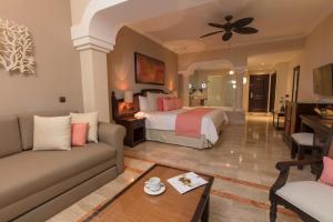um quarto de hotel com uma cama e um sofá em Grand Palladium White Sand Resort & Spa - All Inclusive em Akumal