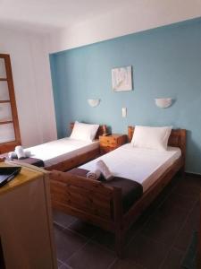 two beds in a room with blue walls at nostalgo in Skiathos Town