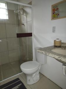a bathroom with a toilet and a shower and a sink at Apartamento - Praia da Ferrugem com Espaço Gourmet in Palhocinha