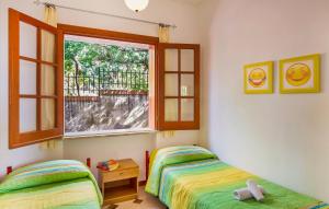 Un dormitorio con dos camas y una ventana. en Villa Belvedere, en Capo Vaticano