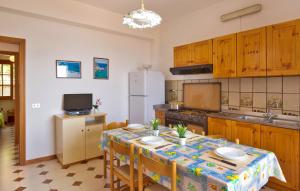 Una cocina con una mesa con sillas y un refrigerador. en Villa Belvedere, en Capo Vaticano 15 fotos más
