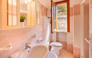 Un baño con lavabo, inodoro y ventana. en Villa Belvedere, en Capo Vaticano