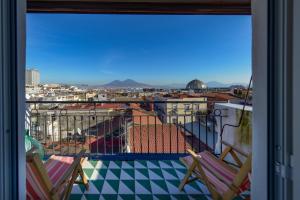 a balcony with two chairs and a view of a city at B&B Toledo Panoramic Rooftop with terrace in Naples