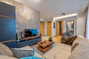 un soggiorno con divano, TV e tavolo di Kalman Royal Inn a Zlatibor