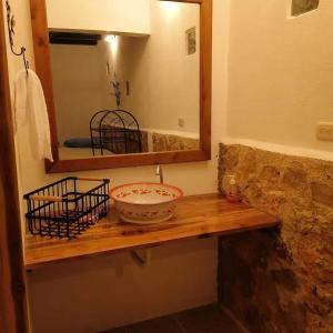 baño con espejo y estante de madera con un bol en Hotel Colibrí Petén, en Santa Elena