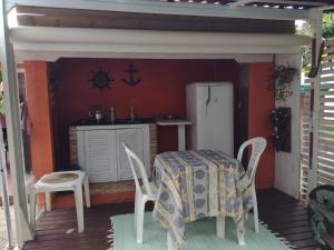 a kitchen with a table and chairs and a refrigerator at Apartamento - Praia da Ferrugem com Espaço Gourmet in Palhocinha