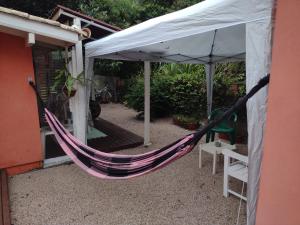 a hammock hanging from a tent outside a house at Apartamento - Praia da Ferrugem com Espaço Gourmet in Palhocinha