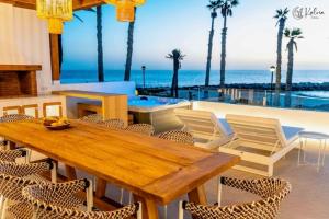 a wooden table and chairs with a view of the ocean at Casa Kalma in Playa Blanca