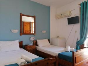 ein blaues Zimmer mit 2 Betten und einem Spiegel in der Unterkunft nostalgo in Skiathos-Stadt