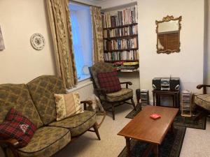 Una sala de estar con un sofá y sillas y una mesa. en Bodwyn house, en Dolgellau