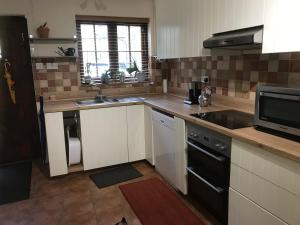 a kitchen with a sink and a stove top oven at Wrens Nest in Axminster
