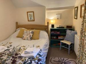 Un dormitorio con una cama y una silla dentro. en Bodwyn house, en Dolgellau