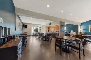 ein Restaurant mit Holztischen und -stühlen und blauen Wänden in der Unterkunft SureStay Plus Hotel by Best Western Highland Poughkeepsie in Highland