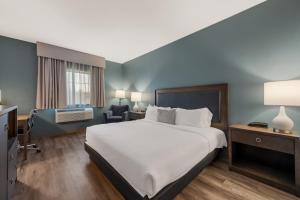 ハイランドにあるSureStay Plus Hotel by Best Western Highland Poughkeepsieの大きなベッドと椅子が備わるホテルルームです。