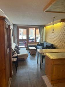 ein Wohnzimmer mit einem Sofa und einem Tisch in der Unterkunft Grand 2 pièces traversant au Val Claret, 4 à 6 pers in Tignes