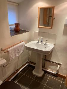 Un baño con un lavabo blanco y un espejo. en Bodwyn house, en Dolgellau