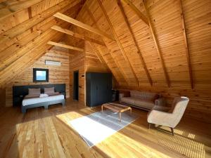 una grande camera in legno con un letto e un divano di Pinhan Otel Kazdağıları a Ayvacık