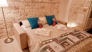 een slaapkamer met een bed met blauwe kussens bij Dimora Imma in Conversano