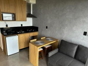 una pequeña cocina con mesa, silla y barra. en Casa Oceano Praia do Rosa, apartamentos pé na areia, Praia do Rosa, en Praia do Rosa