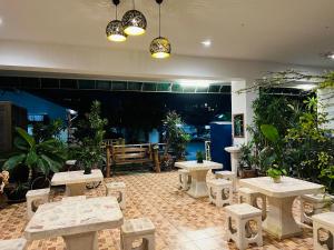 a patio with tables and benches and potted plants at JJ Palace เจเจ พาเลซ in Ban Si Than