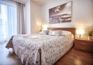 a bedroom with a bed with a white bedspread at Apartamenty Na Wyspie - Casa Marina - Parking in Świnoujście