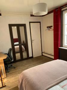 - une chambre avec un lit, un bureau et des miroirs dans l'établissement 2 chambres dans maison calme proches des châteaux de la Loire, à Veigné