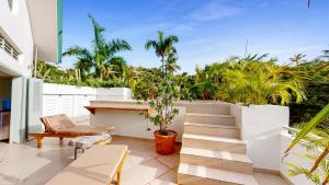 an outdoor patio with a white fence and plants at Tropical Penthouse in the Heart of Las Terrenas! in Las Terrenas