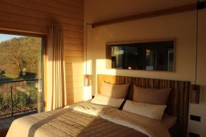 a bedroom with a bed and a balcony with a window at Oaktree-Cottage in Löhnberg