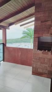 a room with a television and a view of the beach at Marques Home in Porto Belo