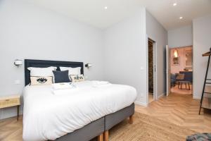 um quarto com uma cama grande e lençóis brancos em Charming appart-6P-Sacré-Cœur Pigalle- PARIS 9 em Paris