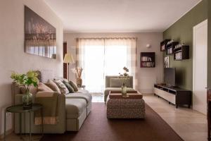 un salon avec un canapé et une télévision dans l'établissement Casa Monteverdi, à Vinchio