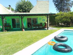 dos neumáticos en una piscina con una casa en Habitación Dulce Descanso en Ezeiza