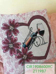 a heart pillow with a glass of wine and a pen at Apartment Maria in Enna