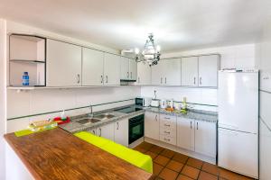 cocina con armarios blancos y mesa de madera en Apartamento Casa Manuela en Capileira - Alpujarra en Capileira