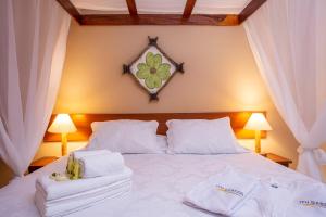 a bedroom with a white bed with towels on it at Itu Garden - SPA e Resort Saudavel in Itu