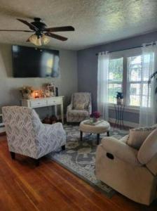 a living room with a couch and chairs and a tv at Mi Casa, Tu Casa in Rupert