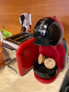 a red toaster sitting on a counter with two cups at HQ Apartment Flora Violet in Borovets