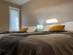 ein Schlafzimmer mit einem großen Bett mit gelben Kissen in der Unterkunft NairaVilla: upscale accommodation for groups in Regina