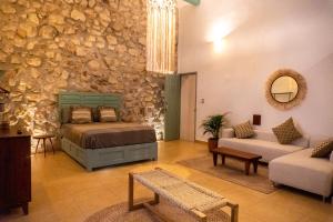 een slaapkamer met een bed en een stenen muur bij Casa Túnez in Campeche